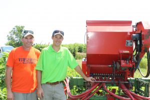 Lee Thompson (left) and Dan Coffman (right) stand next to the cultivator turned covercrop planter.