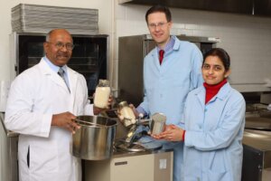 Padmanaban Krishnan with two other scientists in lab coats, holding refined food grade distillers grains, exploring DDGS usage 